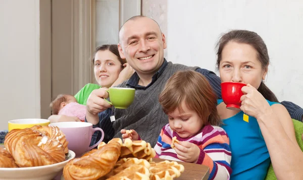 Happy family having tea and cakes