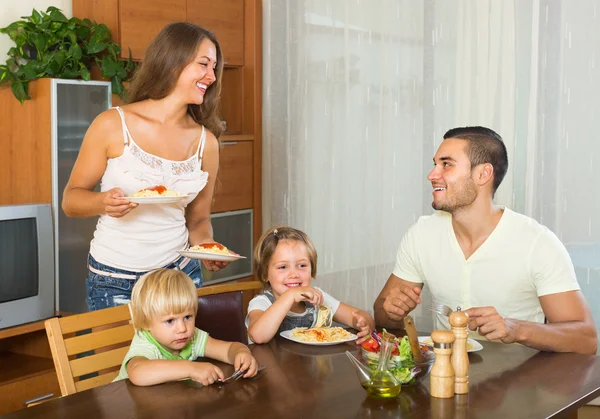 Family of four eating spaghetti