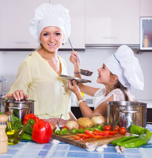 Mom and little daughter cooking