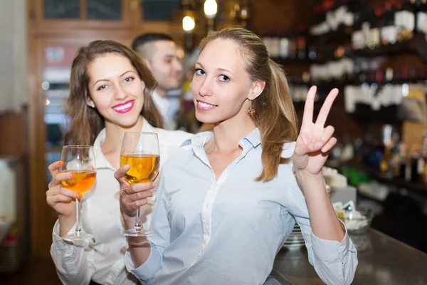 Two girls with man at bar
