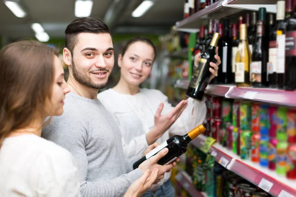 Man and women choosing wine bottles