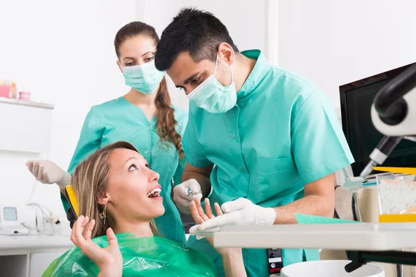 Dentist with assistant and scared patient