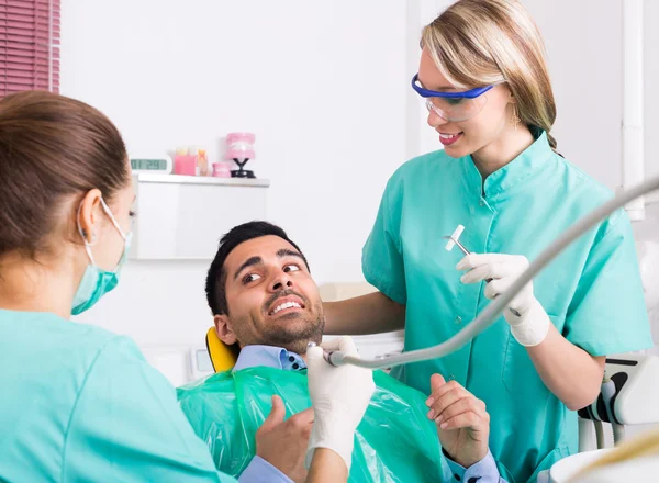 Dentist with assistant and scared patient