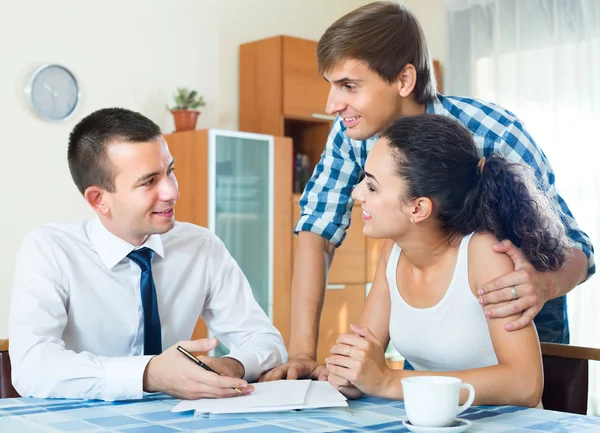 Young couple and banking agent indoors