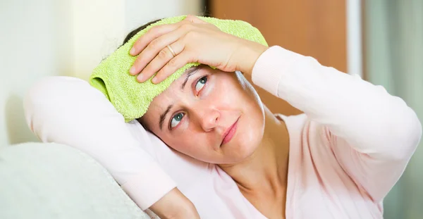 Woman with headache at home