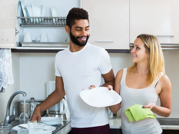 Couple dusting in domestic kitchen