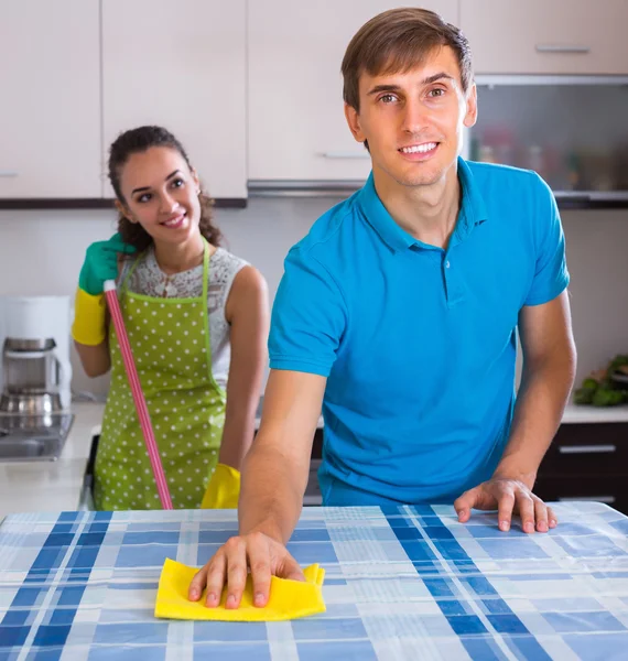 Young couple cleaning at kitchen