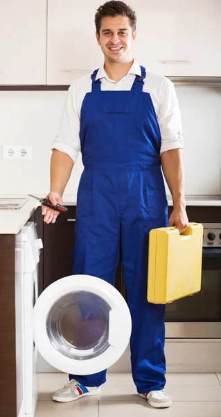 Serviceman posing near washing machine