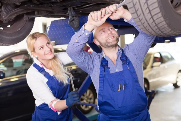 Mechanic and assistant working at garage