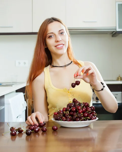 Positive young woman with cherries