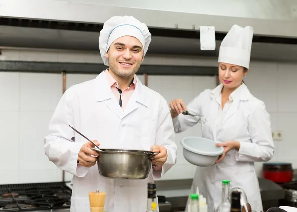 Two cooks at restaurant kitchen