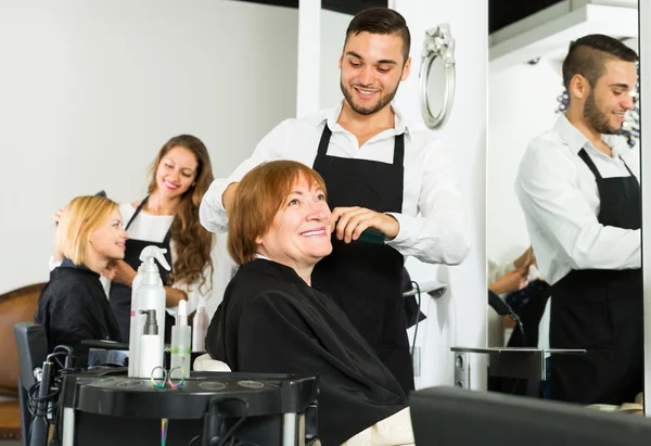Woman cuts hair at the hair salon
