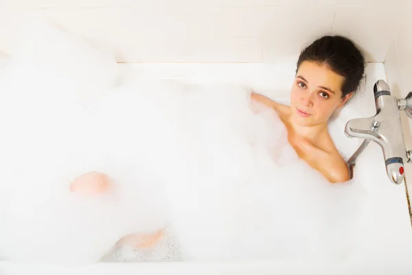Young girl covered foam in bath