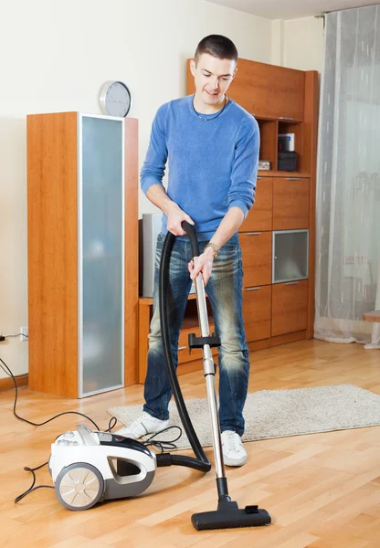 Man  cleaning with vacuum cleaner in living room