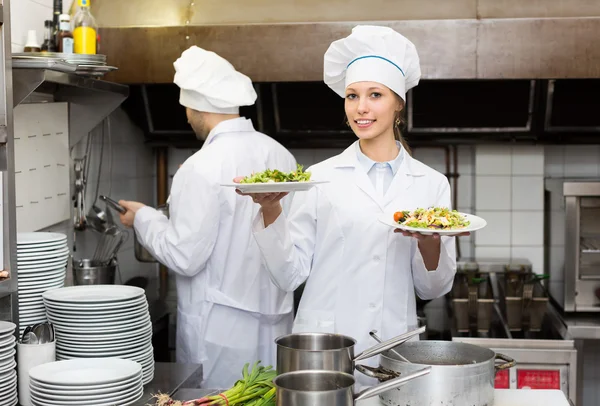 Two cooks at restaurant kitchen