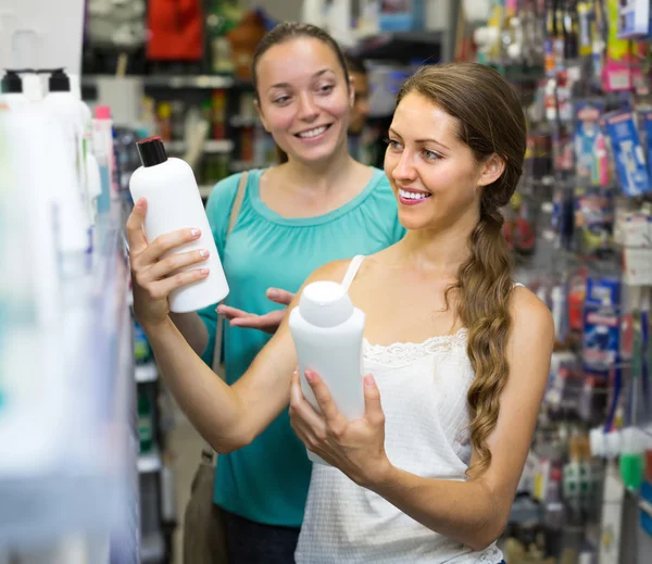 Women choosing shampoo at store