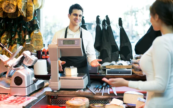 Portrait of seller offering different cheese