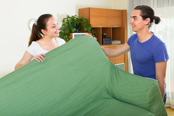 Couple moving furniture in room