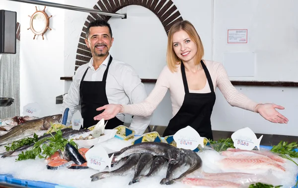 Two sellers in fish section of supermarket