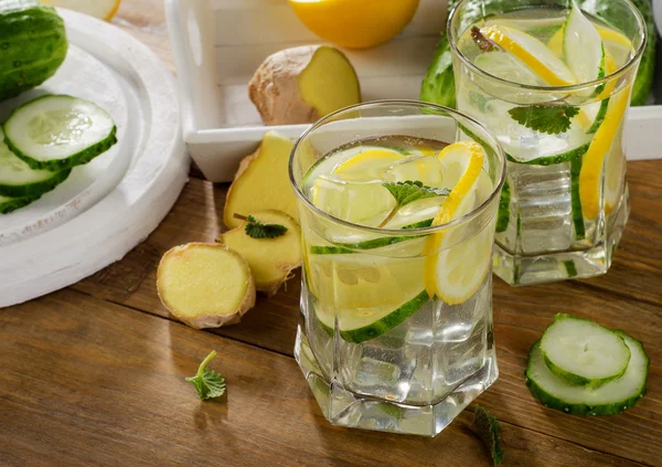 Fresh water with lemon, mint  and cucumber  on a wooden backgrou