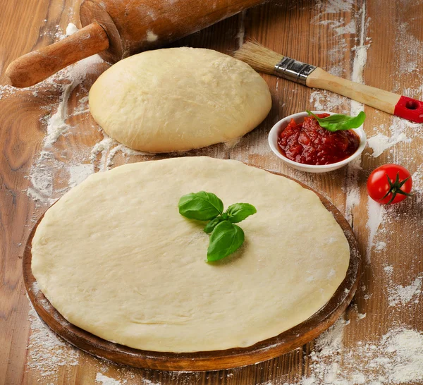 Pizza dough with tomato sauce