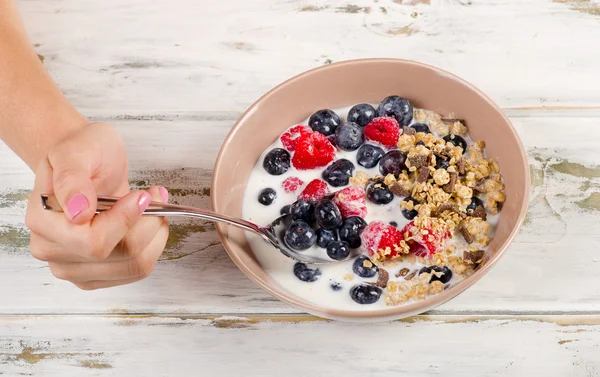 Spoon filled with  muesli and berries.