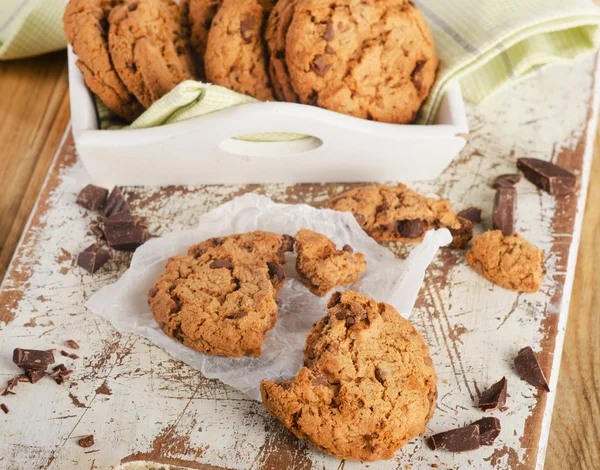 Chocolate chip cookies on a white wooden board.