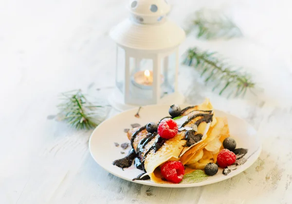 Delicious Christmas sweet breakfast. Crepes with berries.
