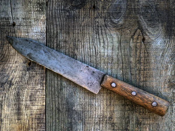 Old knife on wooden background