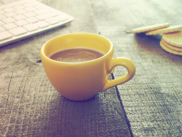 Computer keyboard, cup of coffee and biscuits