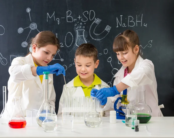 Three little students on chemistry lesson in lab