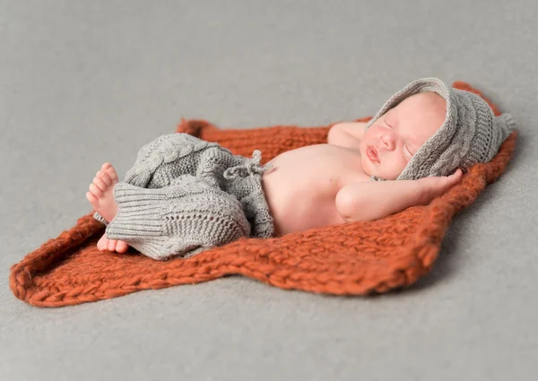 Little newborn baby sleeping on knitted blanket