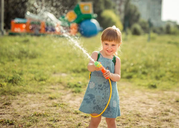 Cute little girl playing water gun