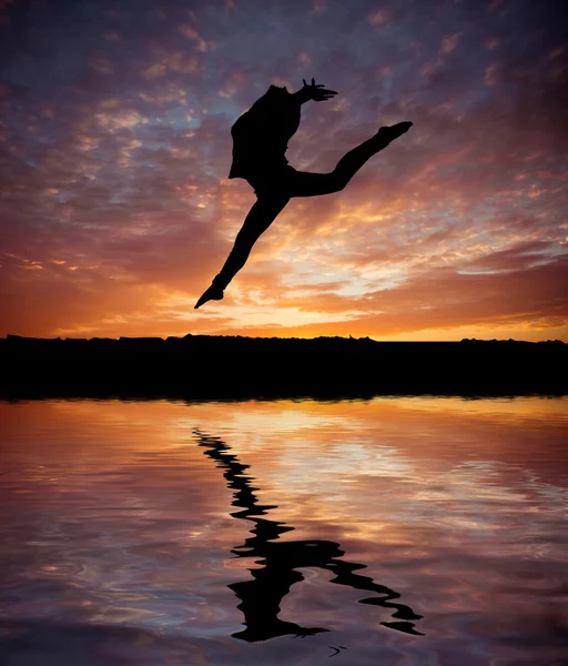 Silhouette jumping  gymnast  at  sunset