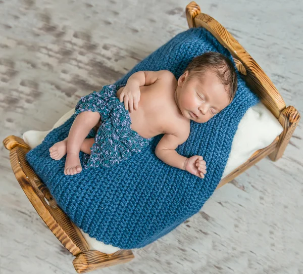 Newborn boy sleeping on blue blanket