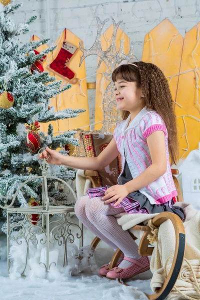 Little girl with gifts under the Christmas tree
