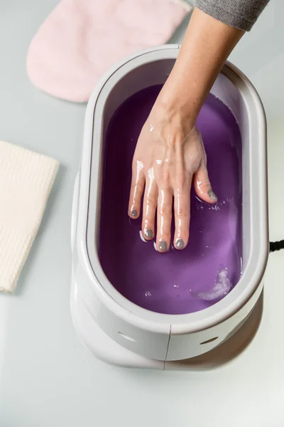 Female hands in a paraffin wax bowl