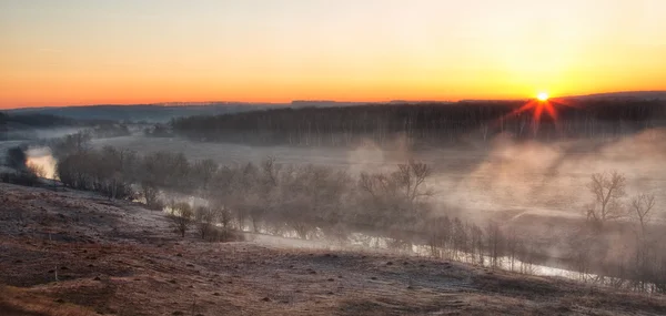 Sunrise through river mist