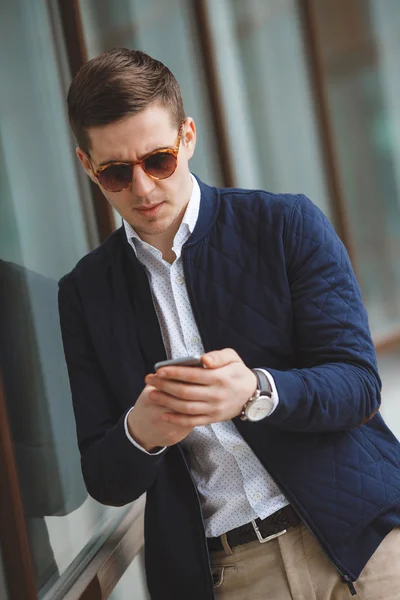 Young businessman talking on cellphone outdoors.