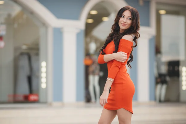 Pretty woman with brown eyes posing on a background of the city.