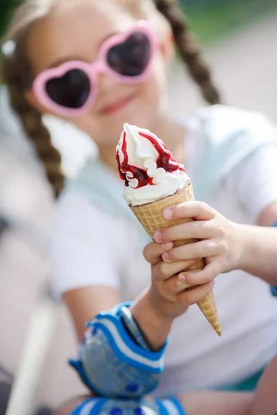 Cheerful little girl in the Park with ice cream cone