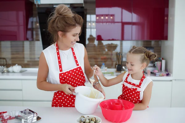 Mother and daughter cooking cupcakes on the festive table