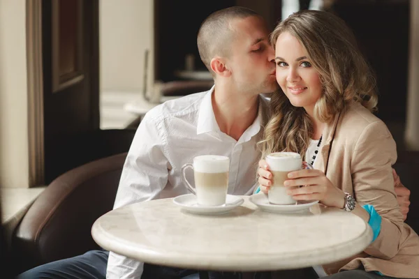 Happy couple drinking coffee in an urban café.