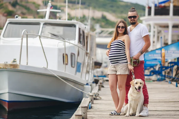 Young couple on a walk in the Harbor with a white Labrador