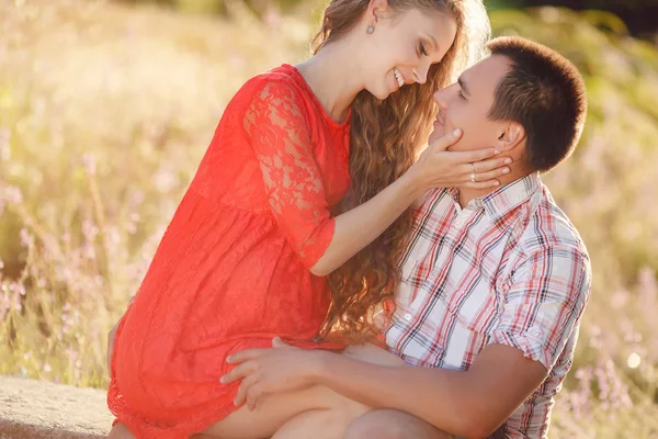 The man and the pregnant woman on a meadow in the summer