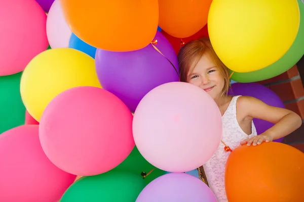 Portrait of little girl playing with air balloons.