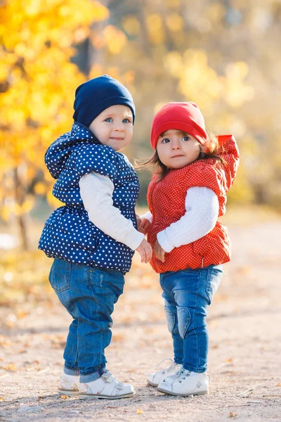 Little girls - girlfriends walk in the park.