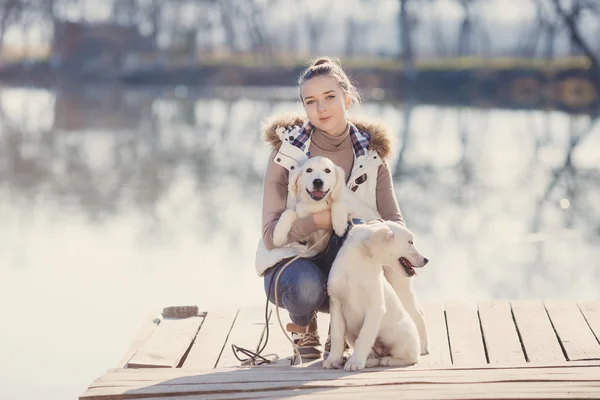 Beautiful girl with pets near the lake
