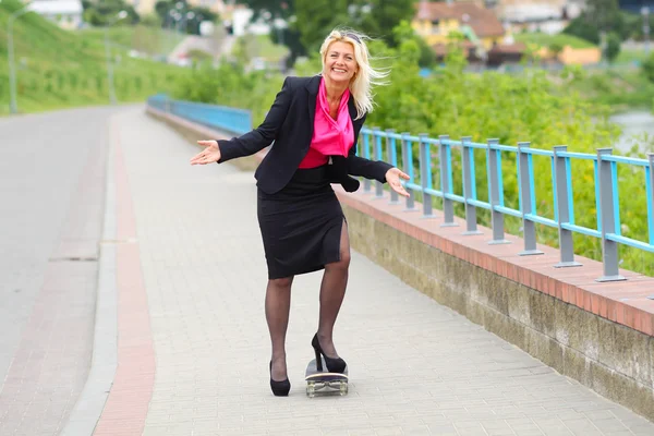 Business woman on a skateboard outdoors