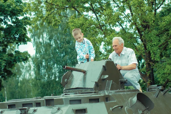 Grandfather shows to  grandson old military artillery